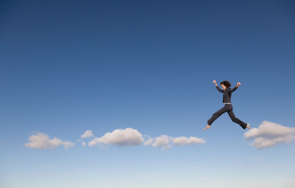 Mixed race businesswoman walking on clouds