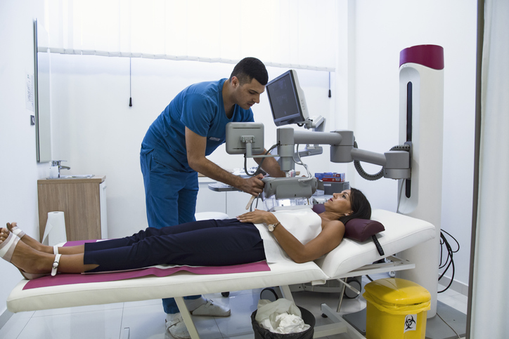 Doctor examining breasts with mammograph
