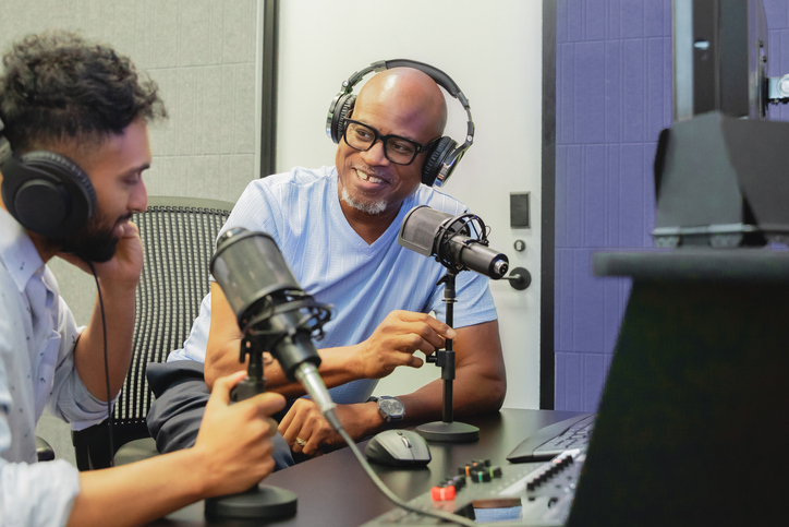 Men discuss politics while recording podcast in modern studio